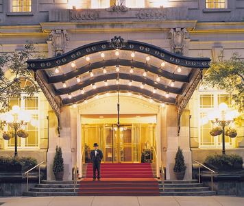 Front entrance of a luxury hotel lit at night.