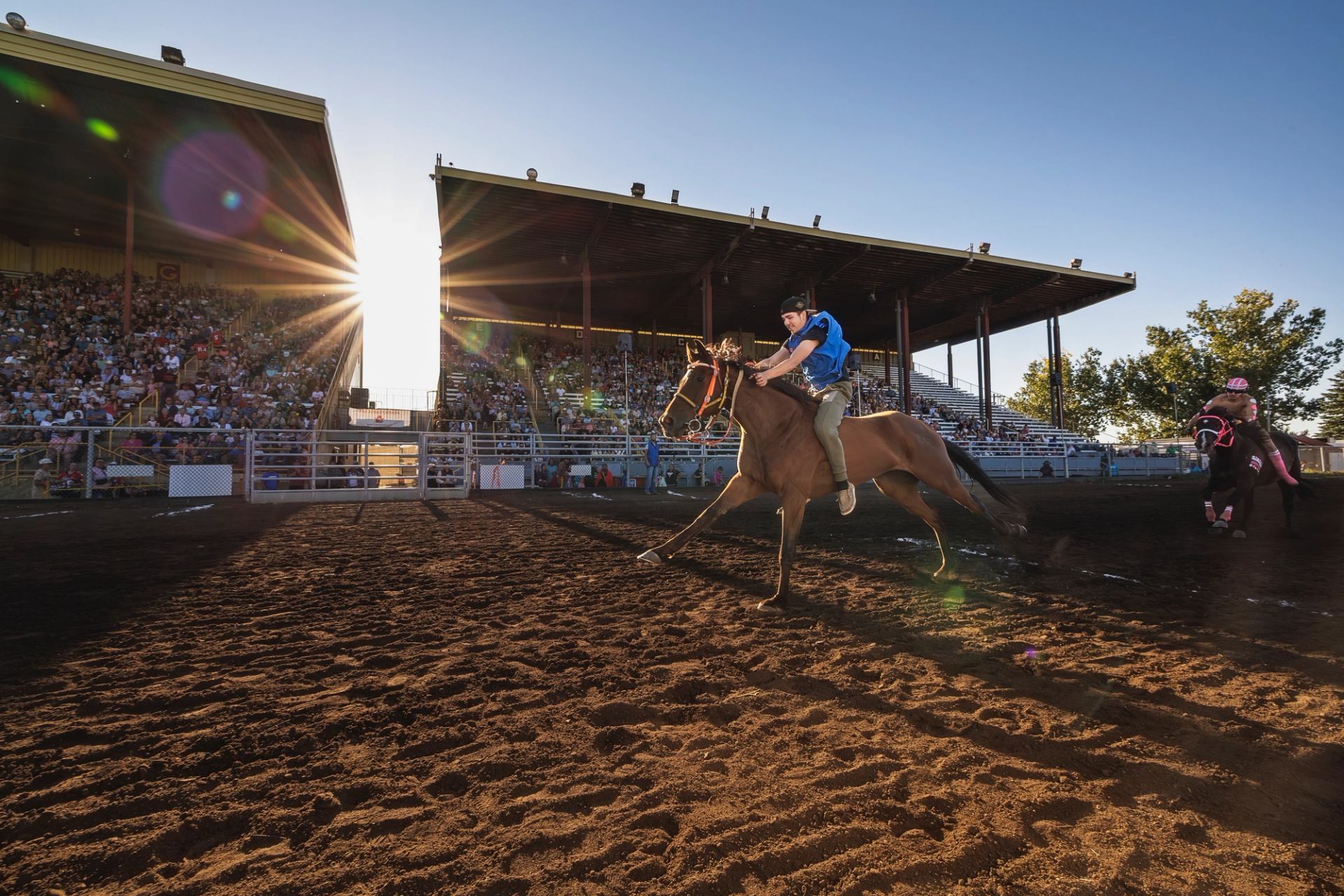Two riders race past a cheering audience during the Indian Relay Race.