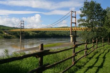 Historic bridge over flowing river in a park.