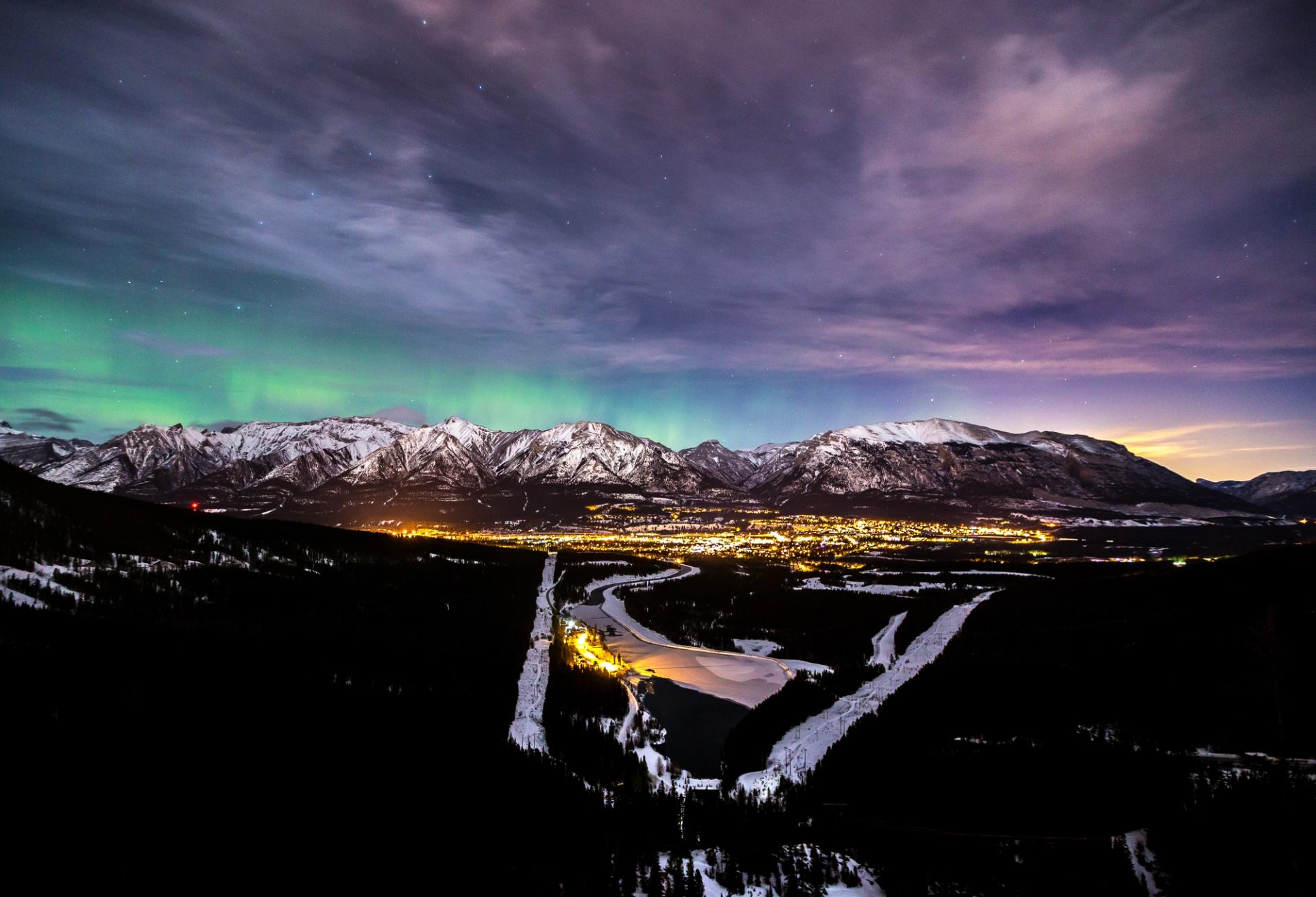 The aurora borealis slights up the night with green and pink light over Canmore, Alberta.