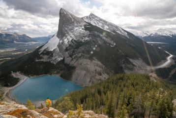 Wide shot of a hiker over looking a lake and mountain view in Banff National Park