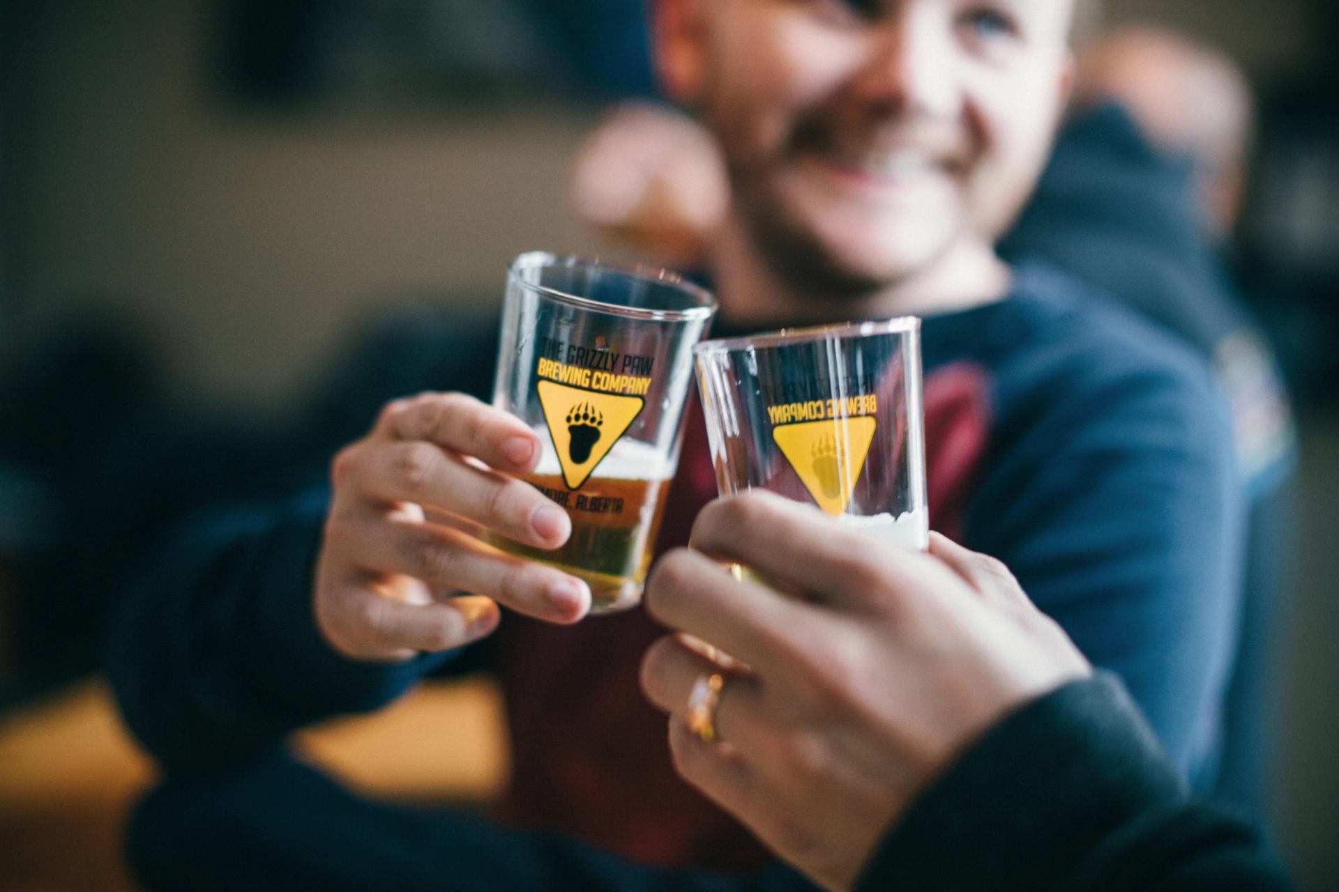 Close-up of friends toasting with glasses of beer at Grizzly Paw Brewing Company in Canmore.