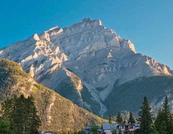 A view from Banff National Park standing on a bridge near Banff Avenue with the Canadian Rockies in the background.