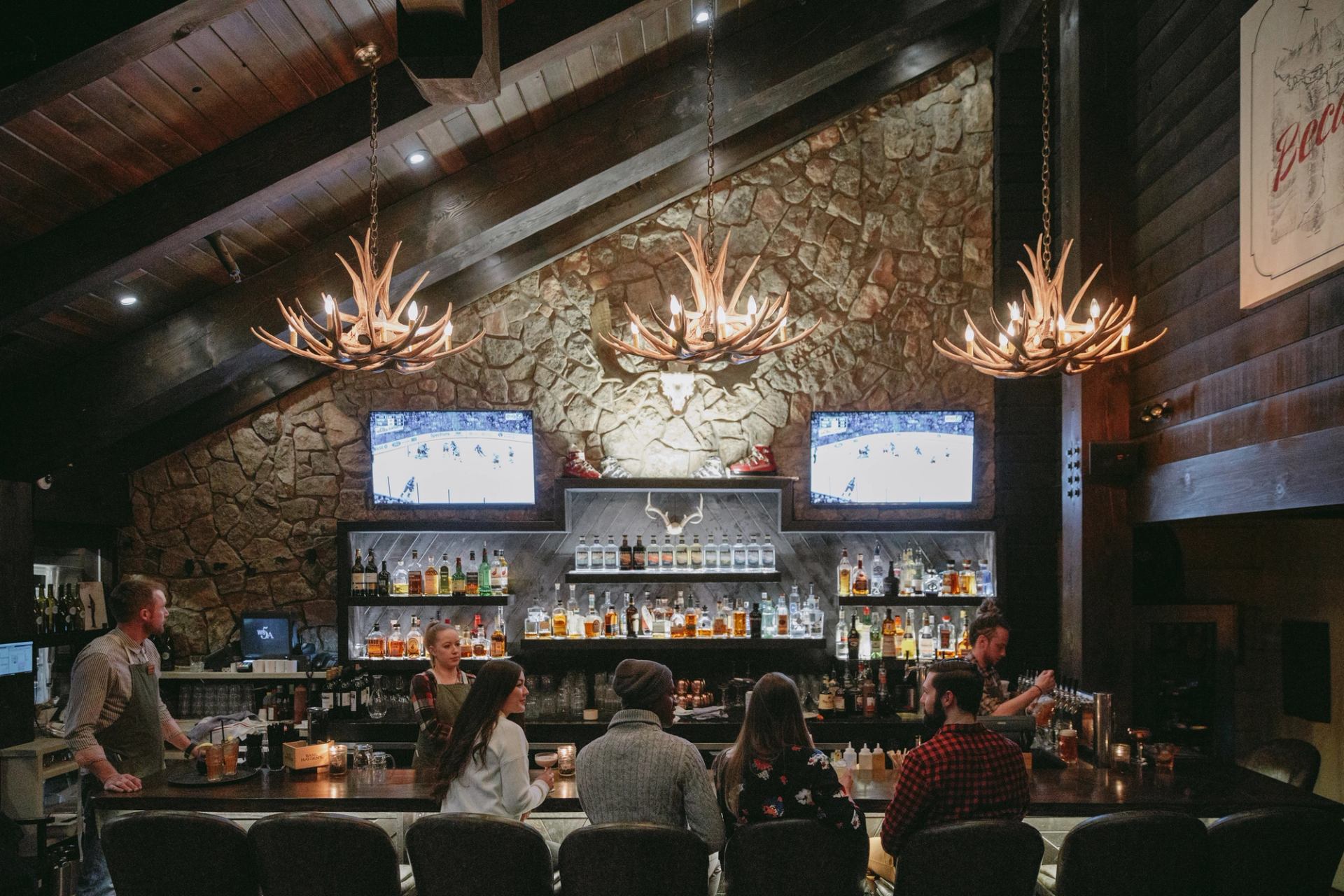 Friends sitting at a bar enjoying some the food and drinks at Park Distillery Restaurant and Bar in Banff.