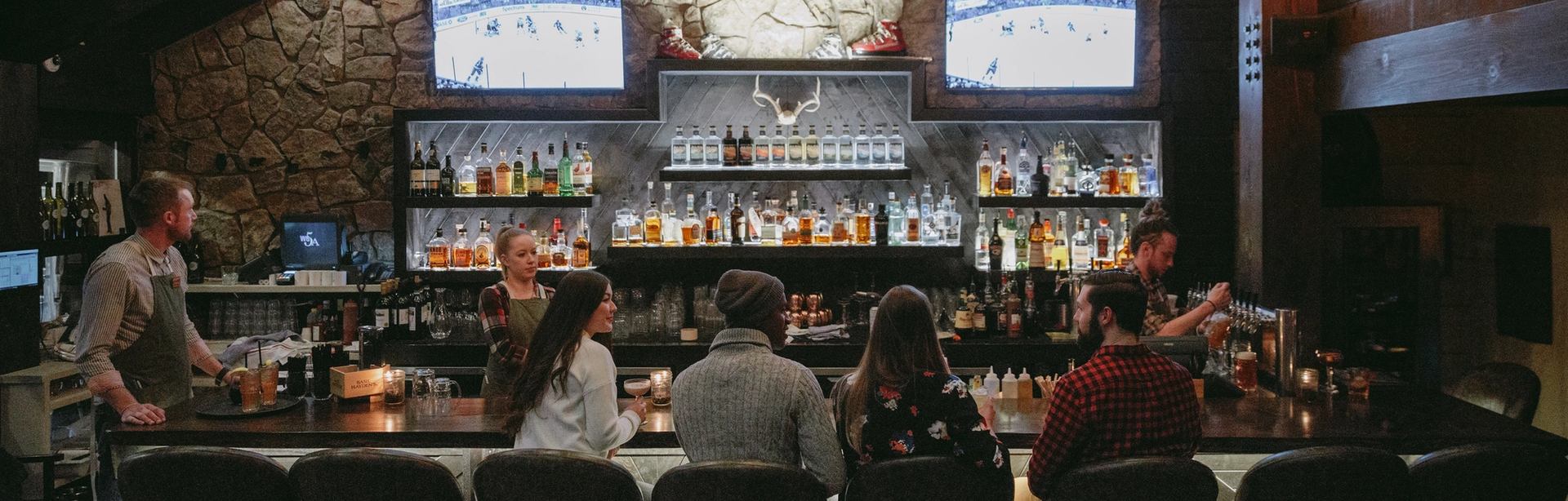 Friends sitting at a bar enjoying some the food and drinks at Park Distillery Restaurant and Bar in Banff.