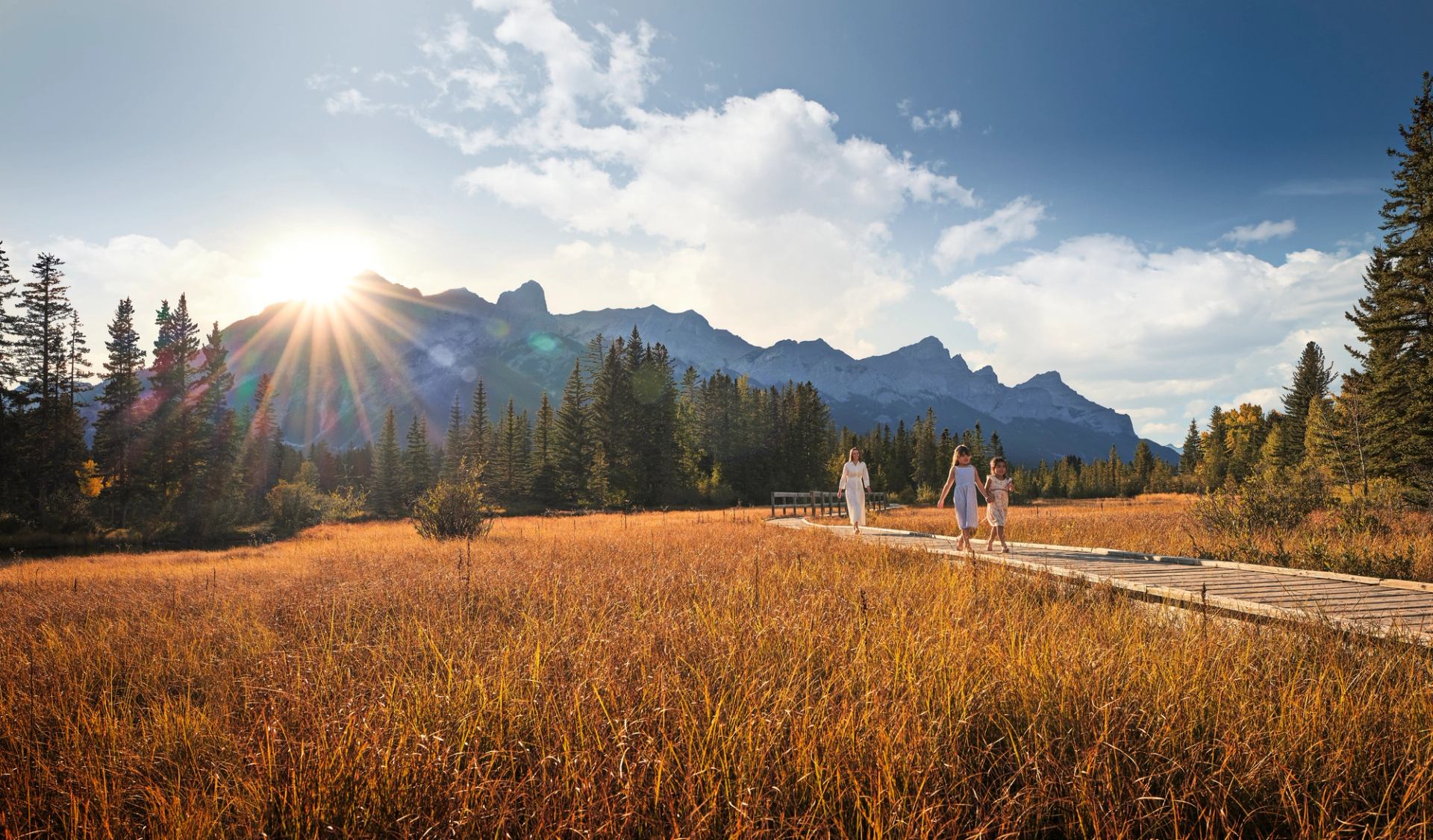 A mother with her two girls exploring the Canmore boardwalk.