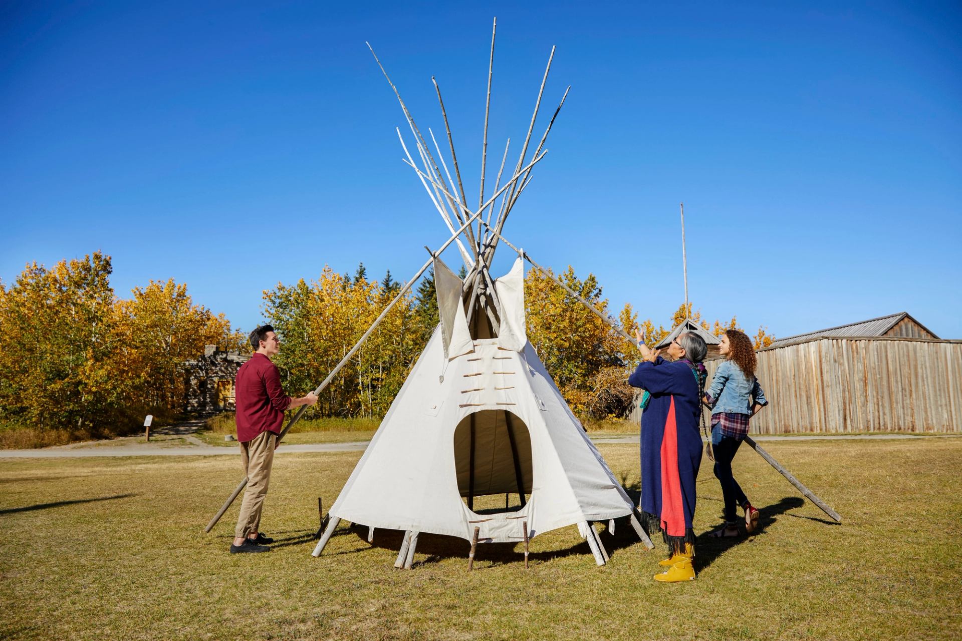 Visitors learning to set up a tipi at Heritage Park Historical Village