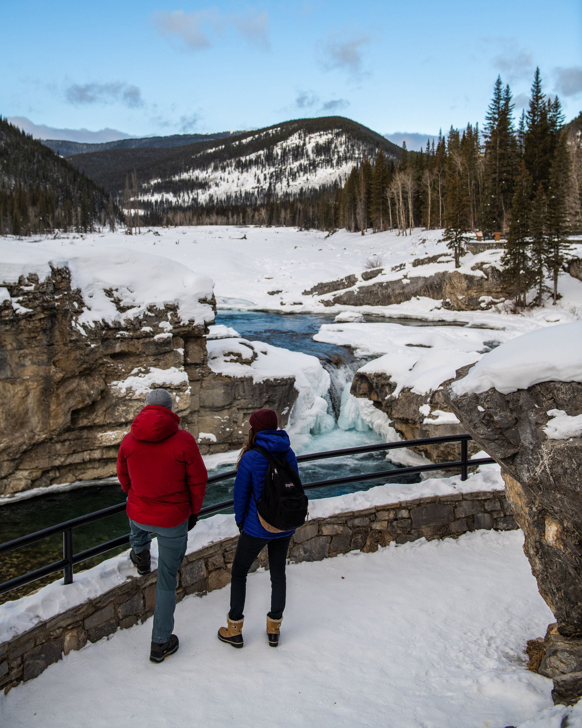 A couple admires the frozen waterfall at Elbow Falls in Bragg Creek.