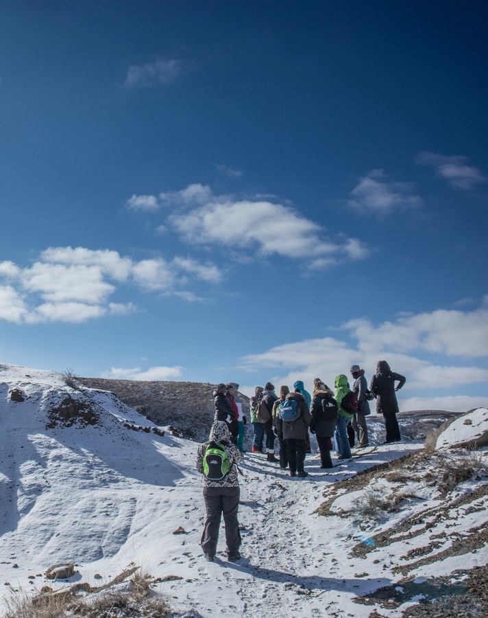 A group of hikers huddle at the top of a trail before continuing their hike at Dinosaur Provincial Park.