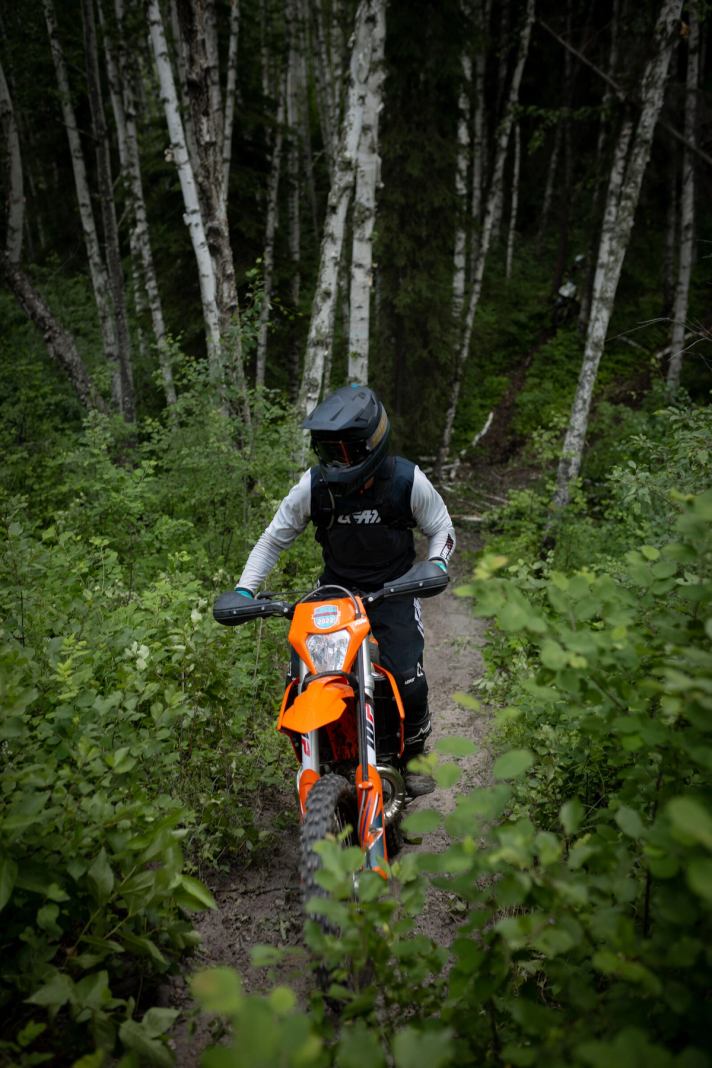 A person rides a dirt bike on a trail in Wood Buffalo.