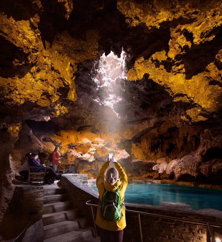 Tourist takes a picture inside a cave.