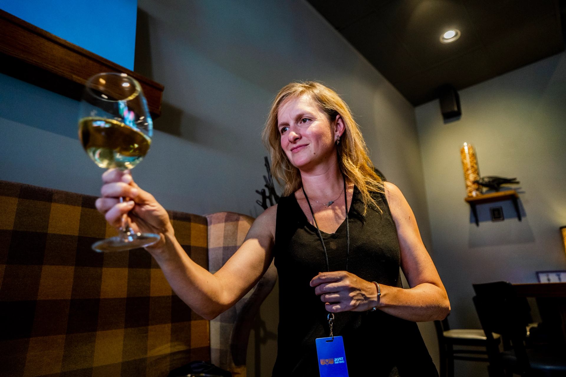 A woman holds a glass of wine at The Raven Bistro in Jasper.