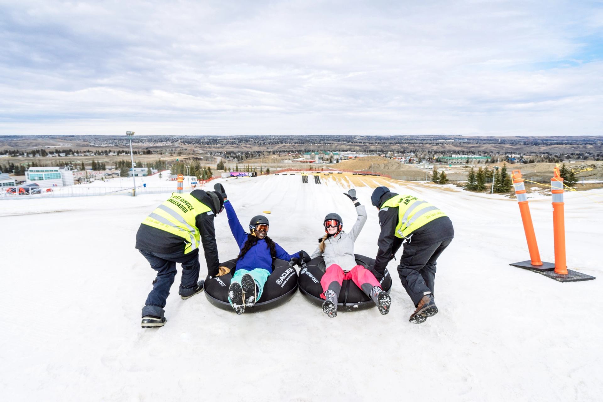 Two friends about to get launched down the tubing hill at WinSport in Calgary.