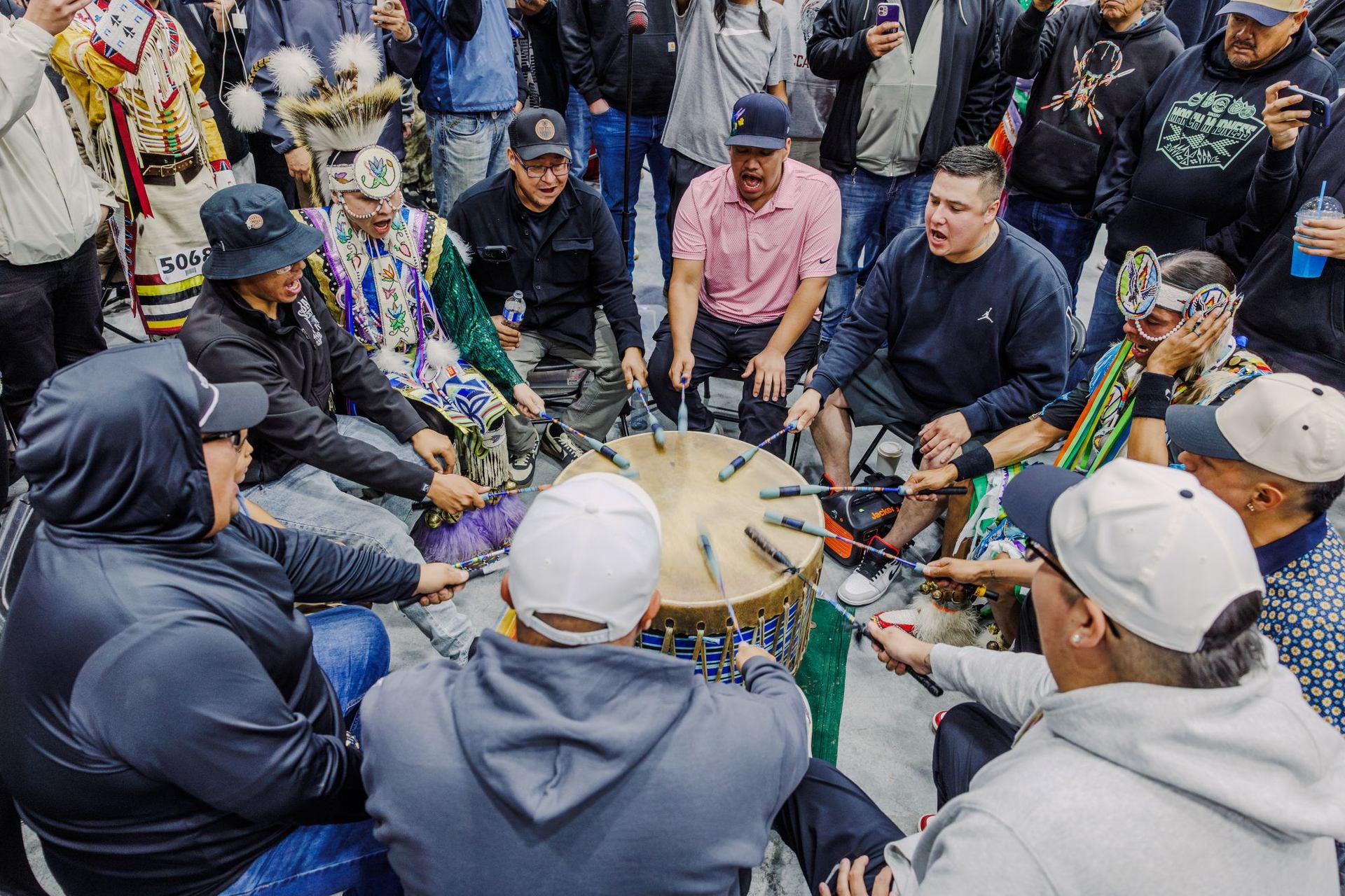 A circle of drummers sing during a performance at a powwow.