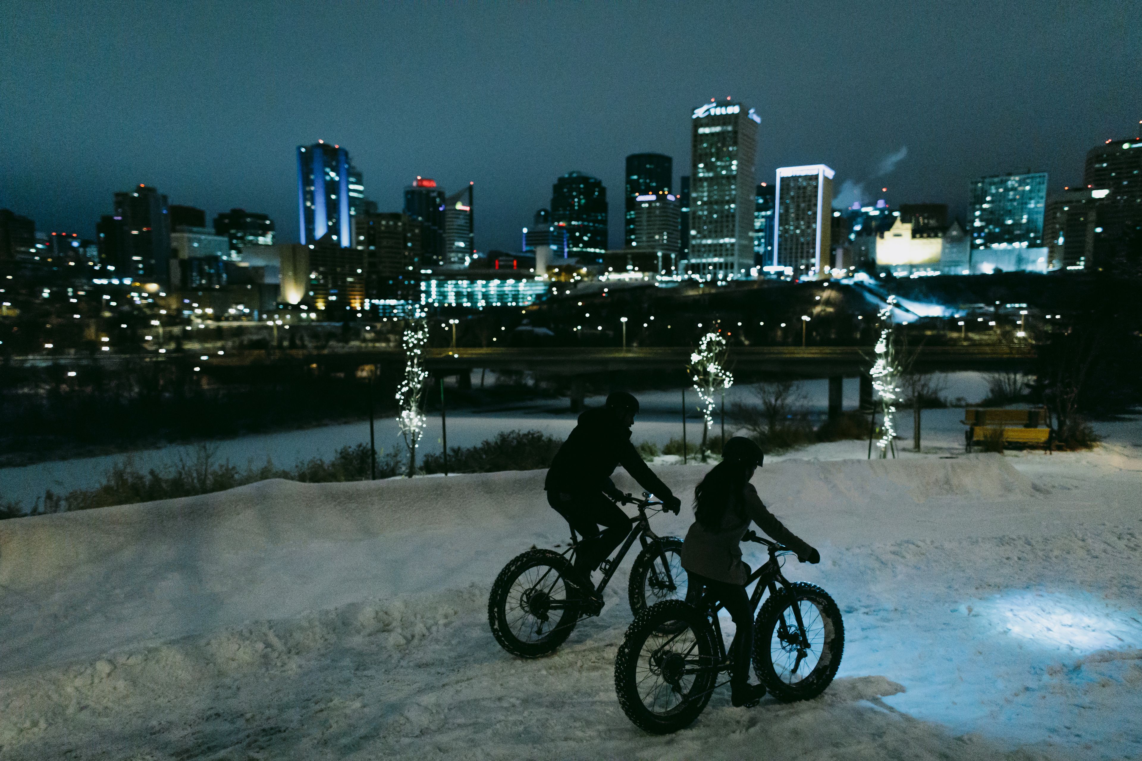 People fatbiking at night by River Valley near Downtown Edmonton