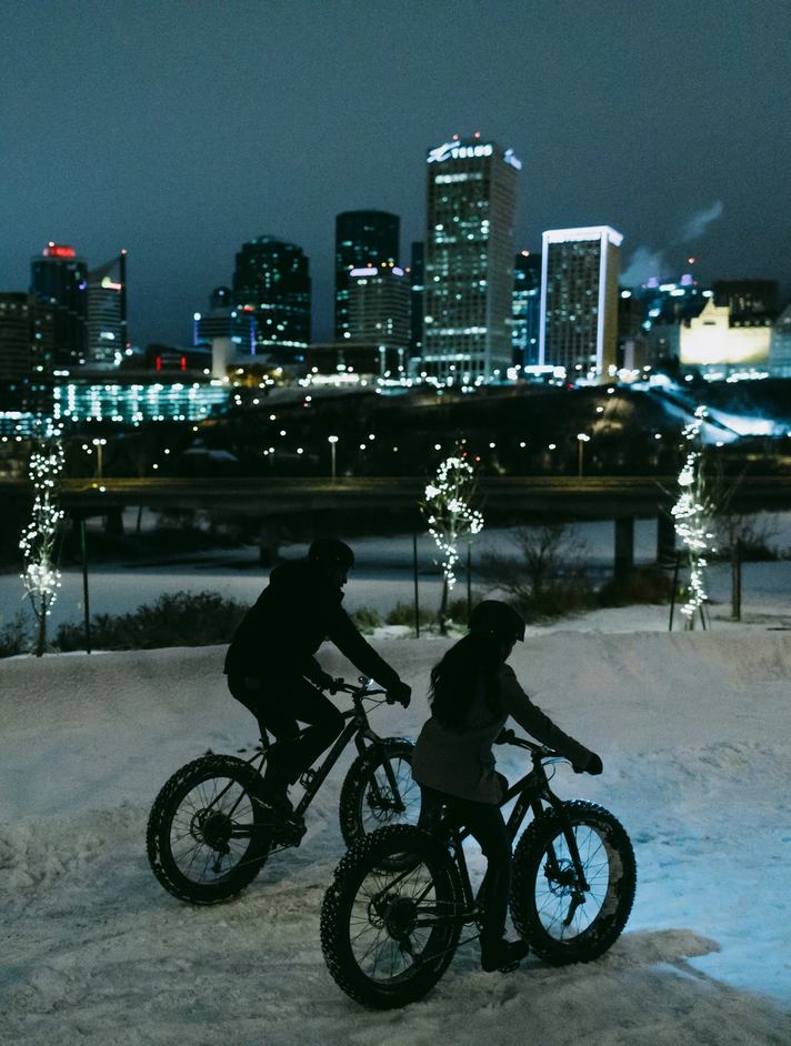 People fatbiking at night by River Valley near Downtown Edmonton