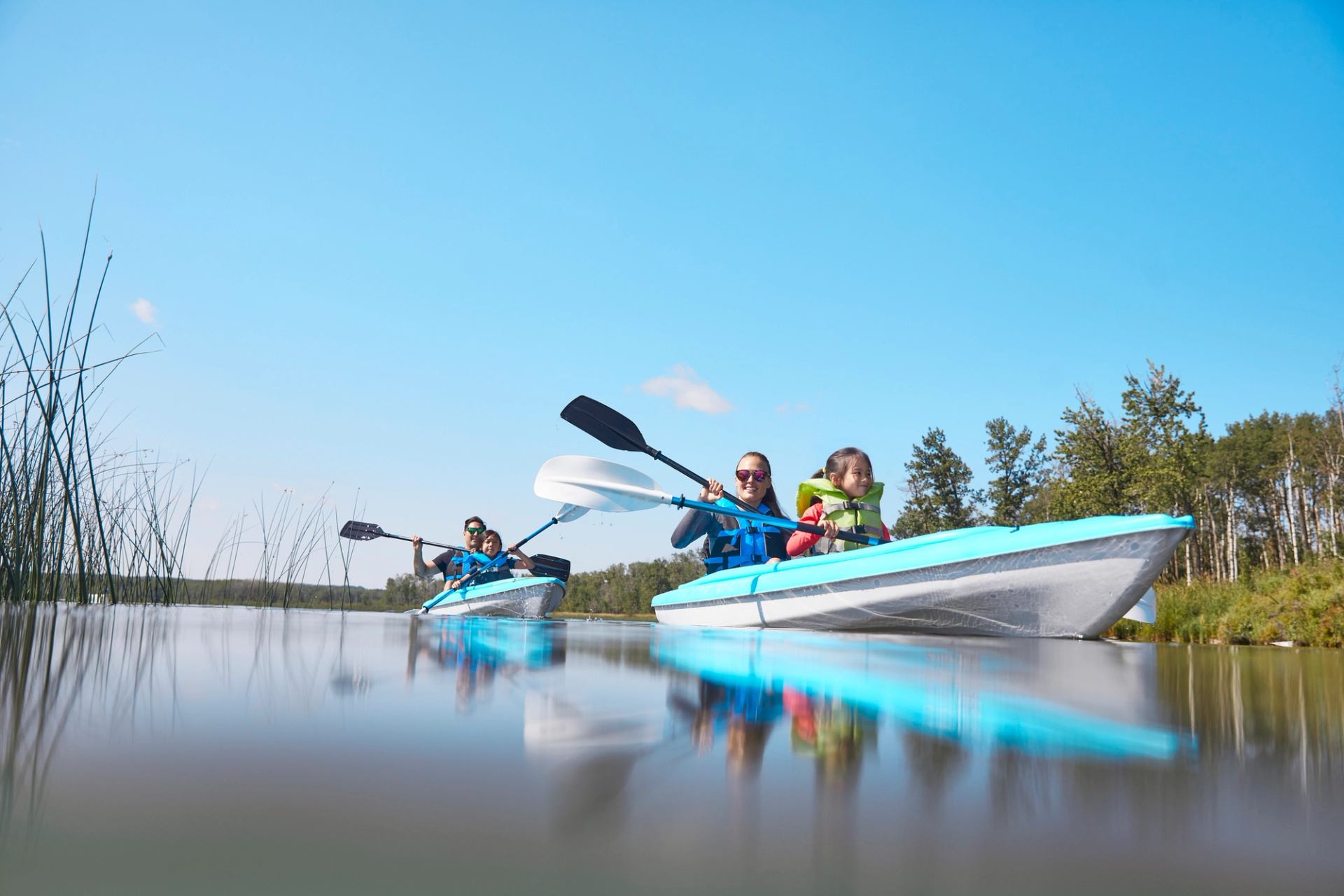 Family paddling canoes at Sylvan Lake on calm water.