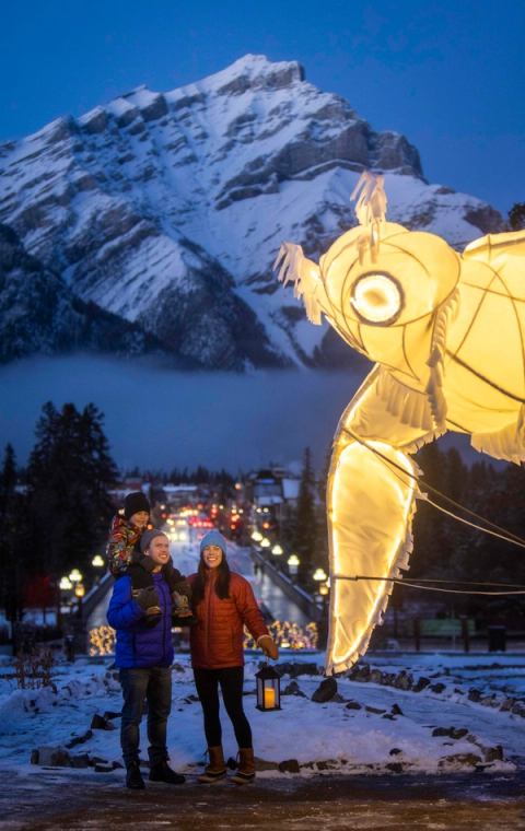 Family looking at a light sculpture with mountain backdrop.