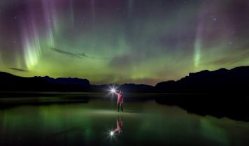 Person looking up at night sky and Northern lights