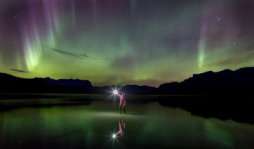 Person looking up at night sky and Northern lights