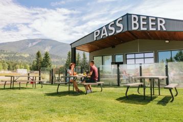 Couple enjoying beers and apps on the patio at Pass Beer.