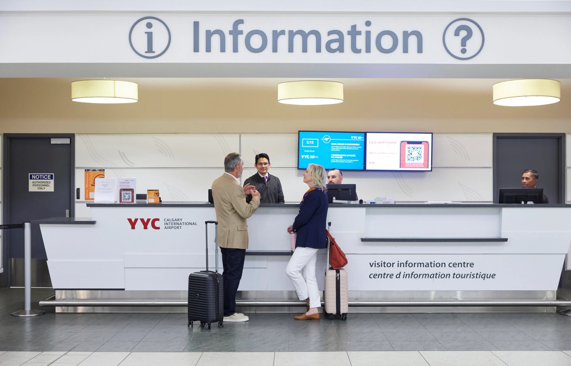 Two travellers get assistance at the Information desk.