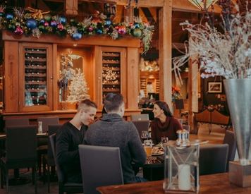 Three people eating around a dining table.