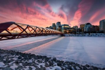 A winter sunrise lights up the sky over Peace Bridge in Calgary.