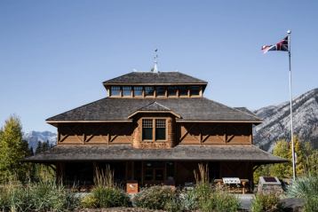 A wood building with mountains in the background.