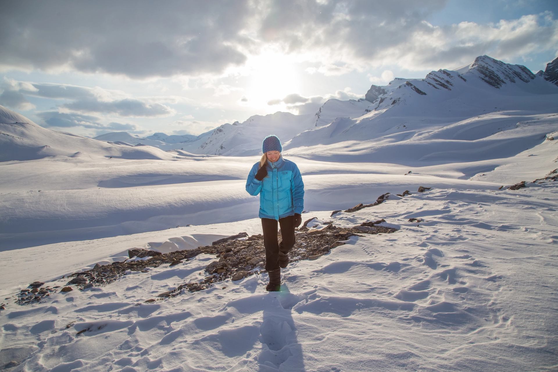 Person hiking in a snow draped landscape in the backcountry.