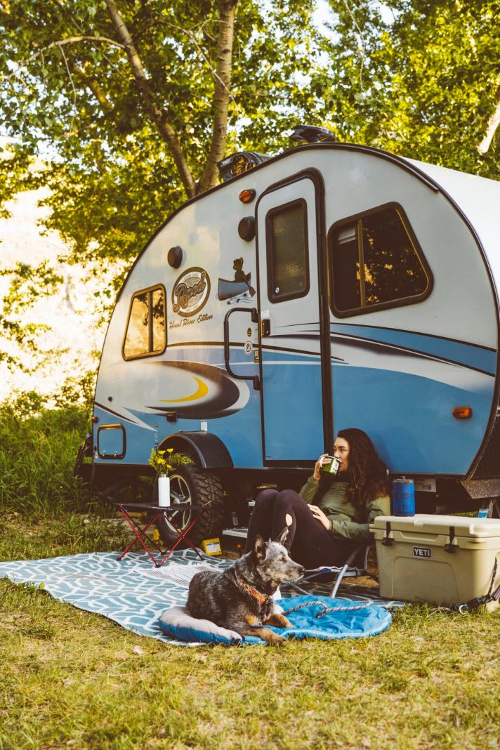 Camper and dog in front of their RV.