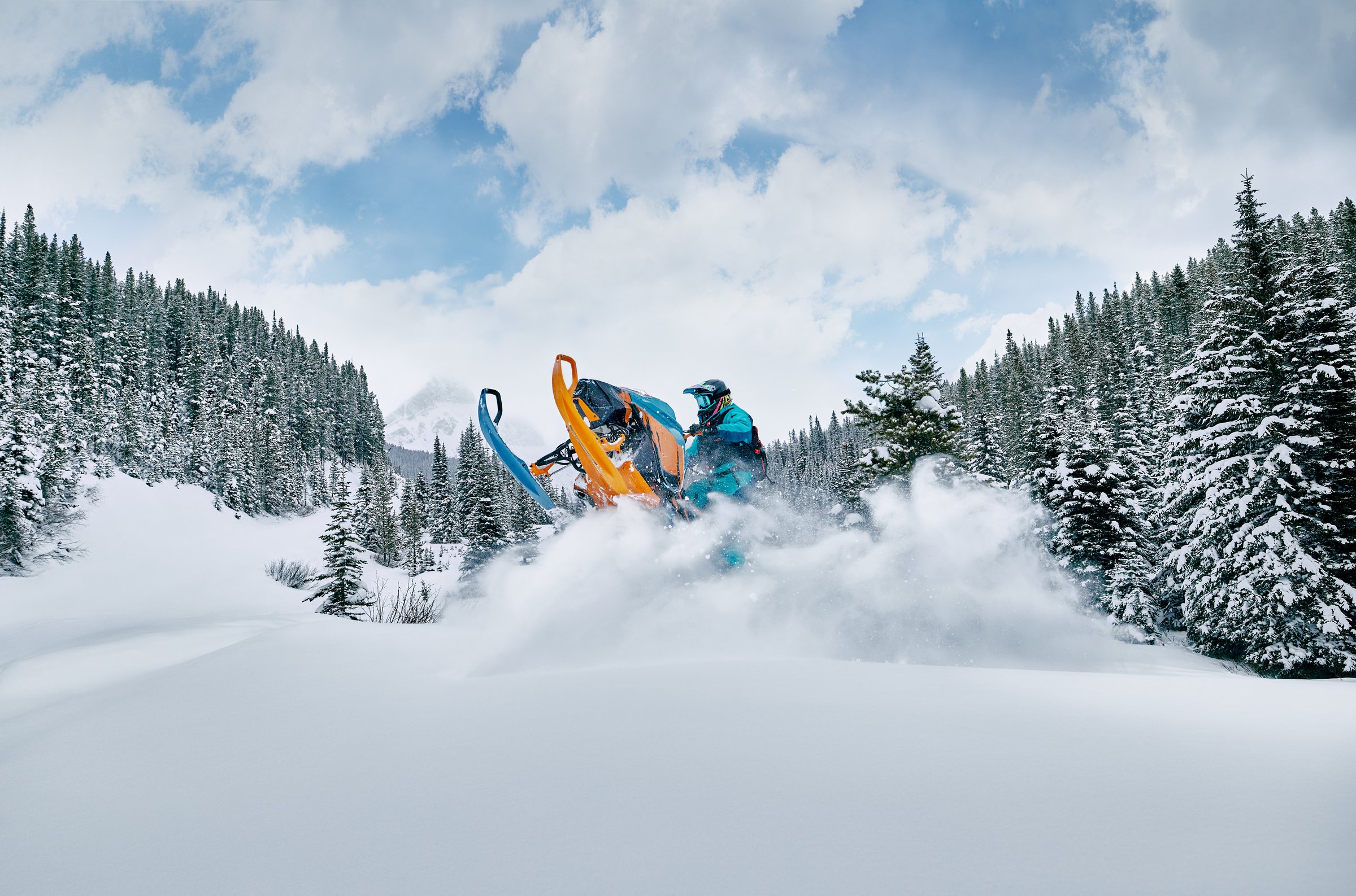 A snowmobiler driving through snow in Crowsnest Pass.