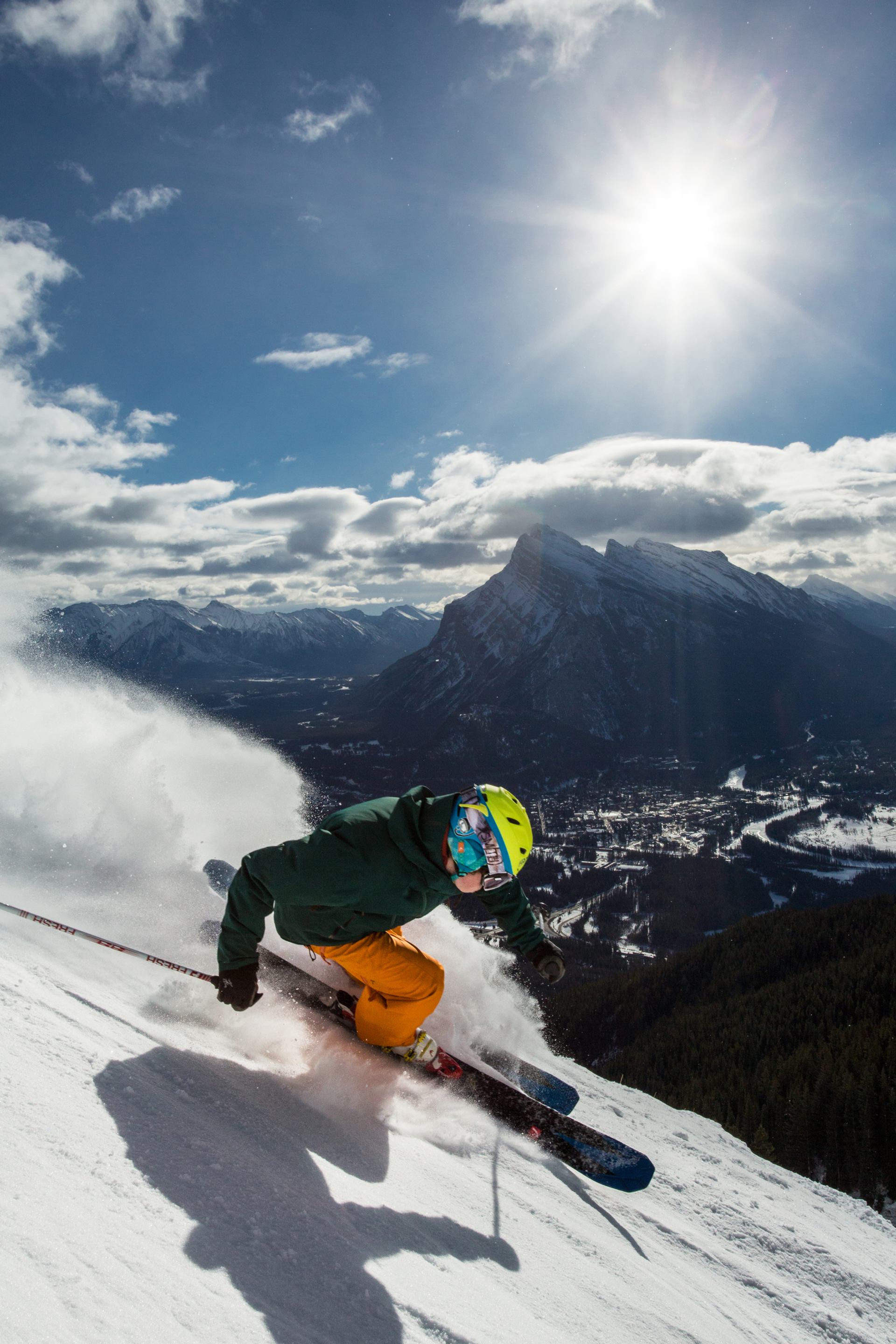 Lone skier tossing up snow as they ride down the mountain.