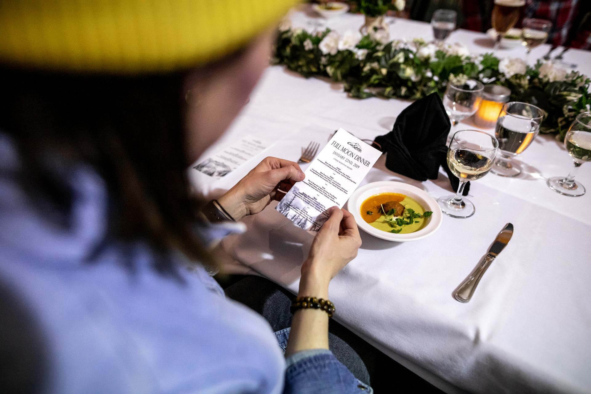 A woman looks at a menu during dinner after the evening snowshoe tour at Castle Mountain Resort.