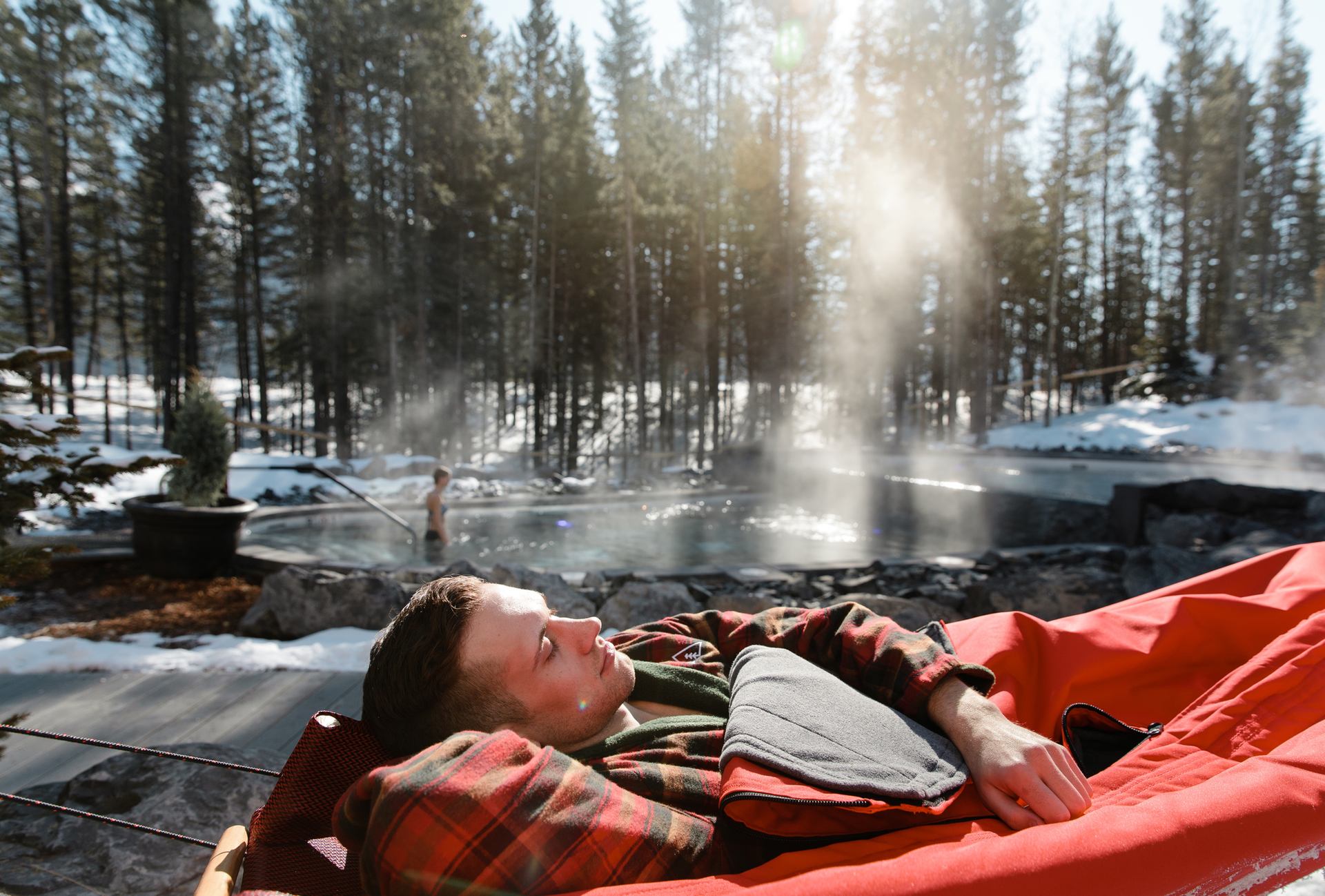 man sleeping in outdoor hammock at Kananaskis nordic spa