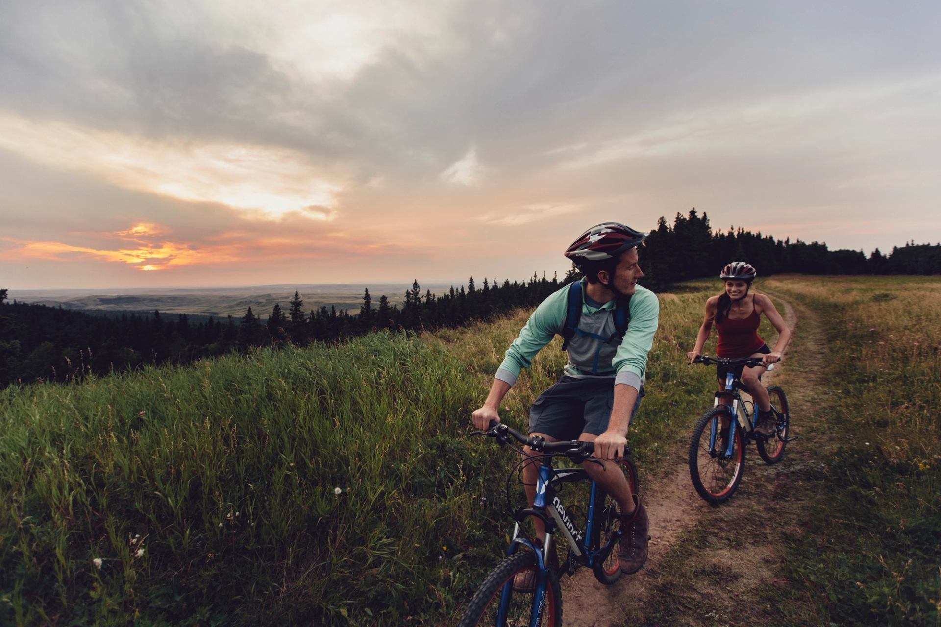 A young couple mountain biking in Cypress Hills Interprovincial Park.