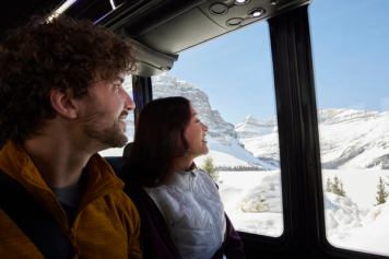 Young Couple enjoying view outside of Sundog bus while driving along the Icefields Parkway