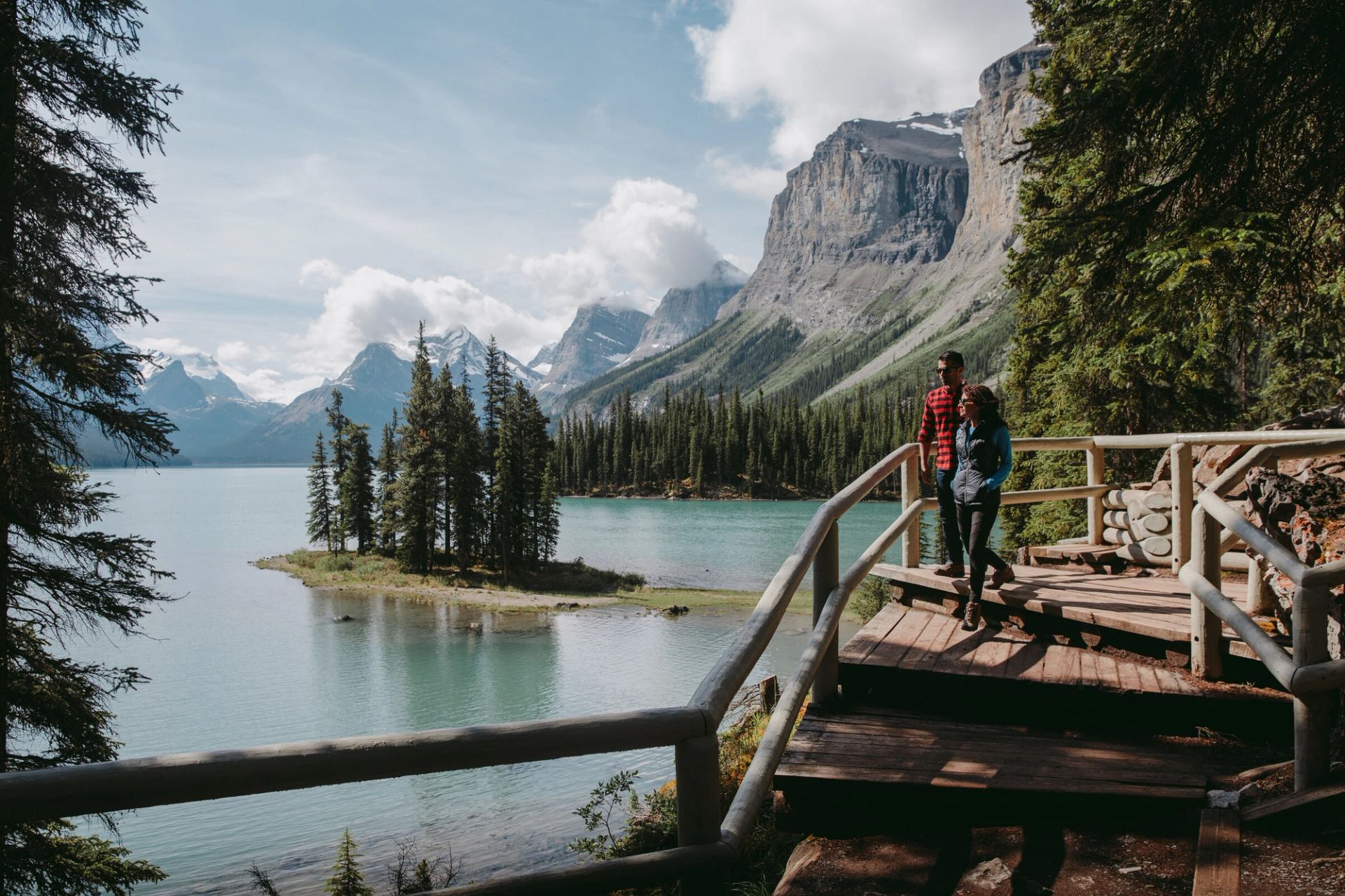 Couple looking out onto Spirit Island at a viewpoint overlooking Maligne Lake in Jasper National Park.