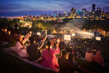 People enjoying performances at night at the Edmonton Folk Festival.