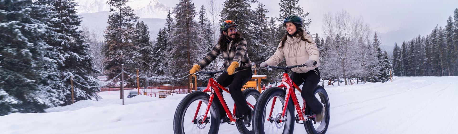 Couple riding fat bikes out at Baker Creek Cabins.