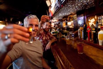 Two friends drinking shooters and beers at the Ship & Anchor pub in Calgary