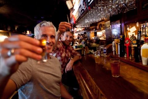 Two friends drinking shooters and beers at the Ship & Anchor pub in Calgary