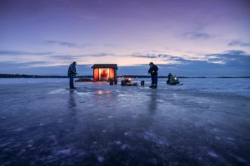 People ice fishing at Sylvan Lake at sunset.