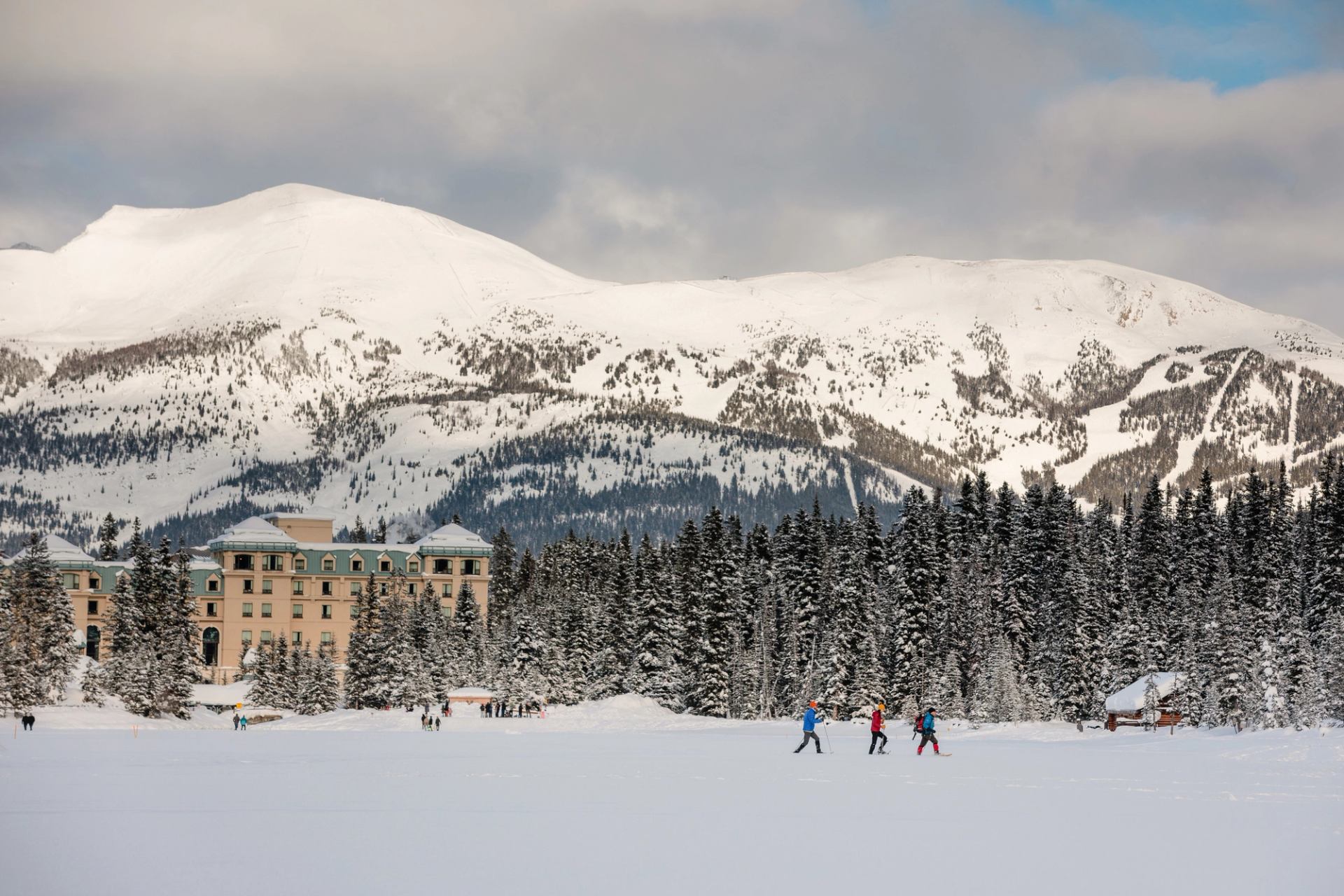 A group snowshoeing next to Fairmont Château Lake Louise.