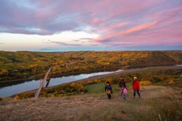 A family hikes up Dunvegan Overlook during the fall time in Peace River.