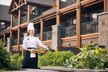 A chef at the Malcolm Hotel in Canmore carries a tray of fresh produce.