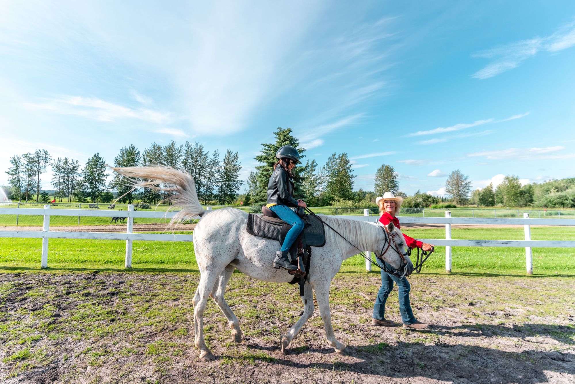 cowgirl leading child on horseback walk