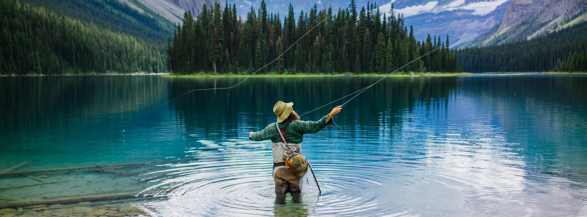 Scenic shot of a man fly fishing at Marvel Lake with a mountain view