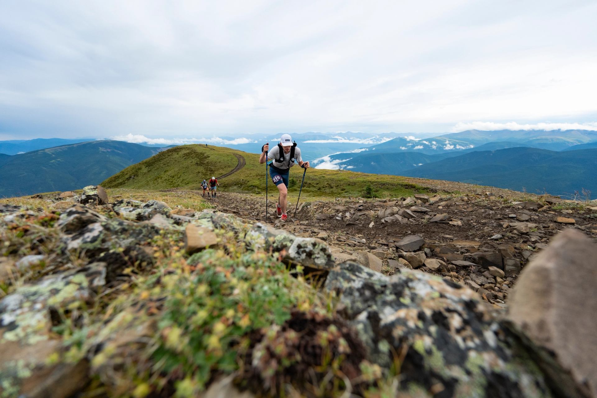 An ultramarathoner hikes a Rocky Mountain summit in the Canadian Death Race near Grande Cache.
