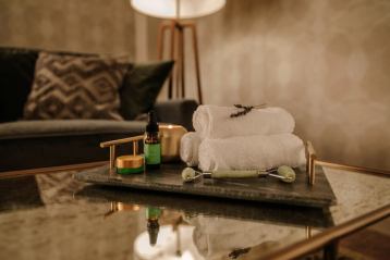 Towels and spa supplies on a table in a dim lit room.